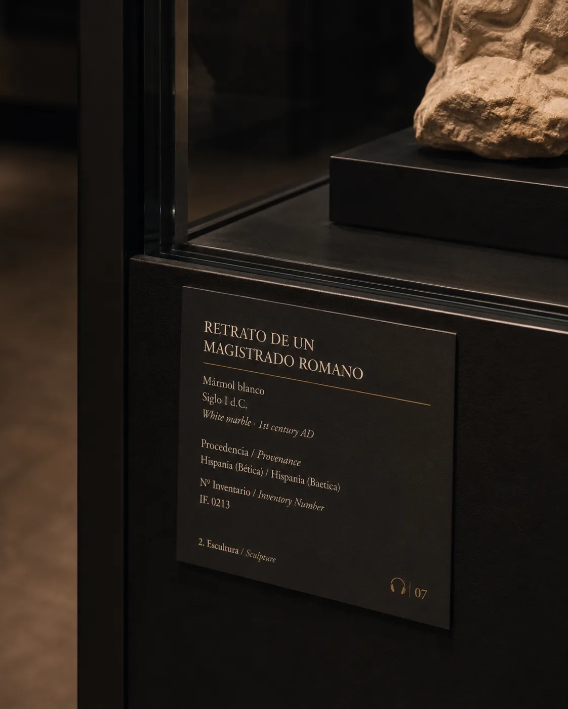 Detalle de una cartela bilingüe junto a la peana de una pieza