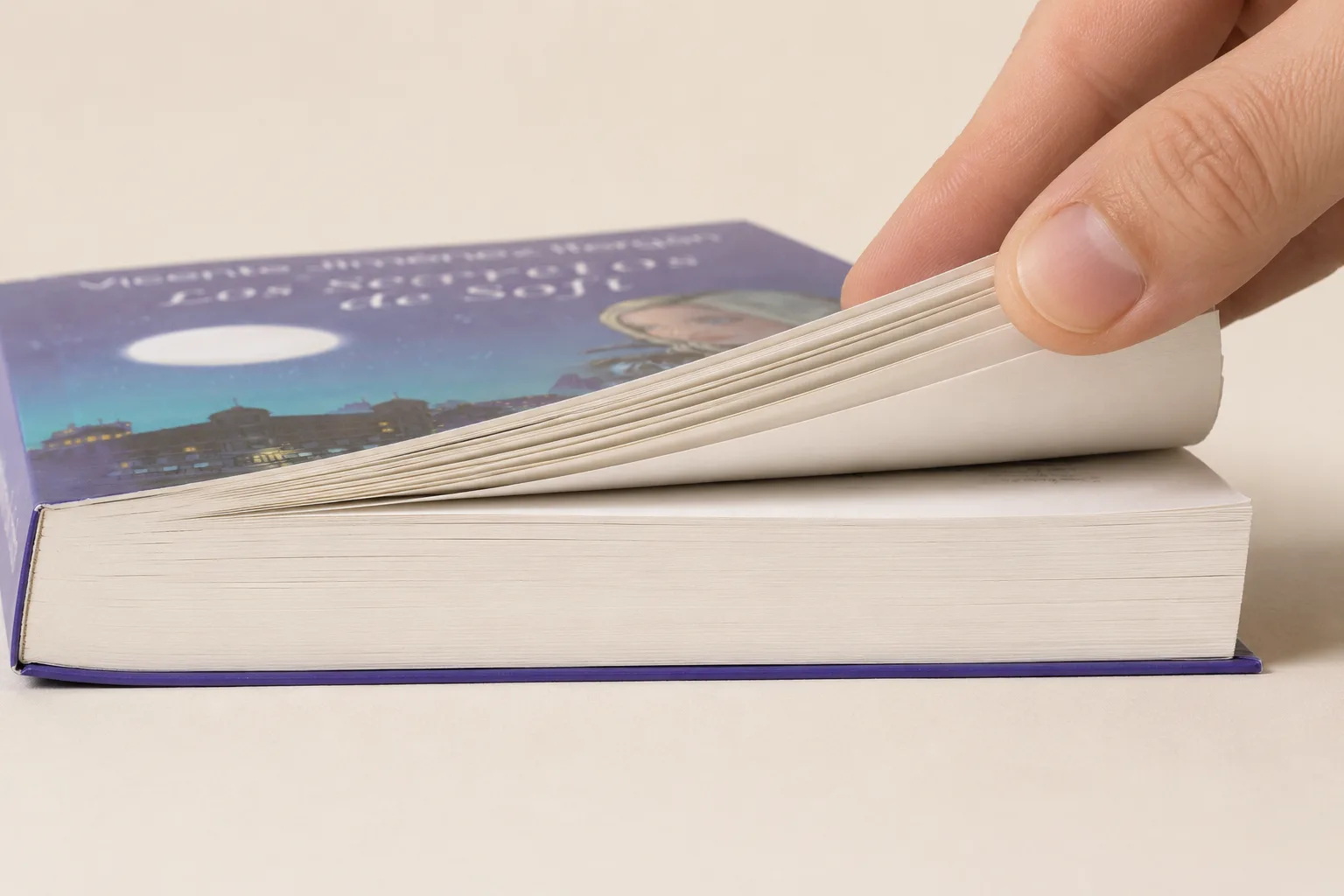 Mano pasando las páginas del libro impreso en papel ahuesado